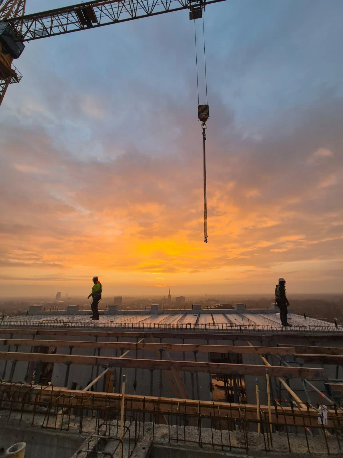 Twee vakmensen van De Beton EXPERT op een gestorte vloer bij zonsopgang