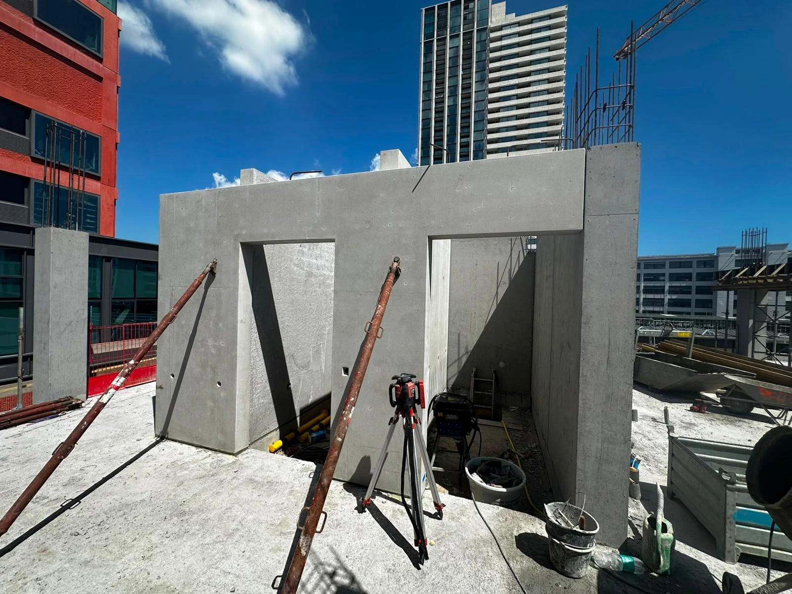 Gestelde prefab betonwanden met schoren en maatvoering op de bouw