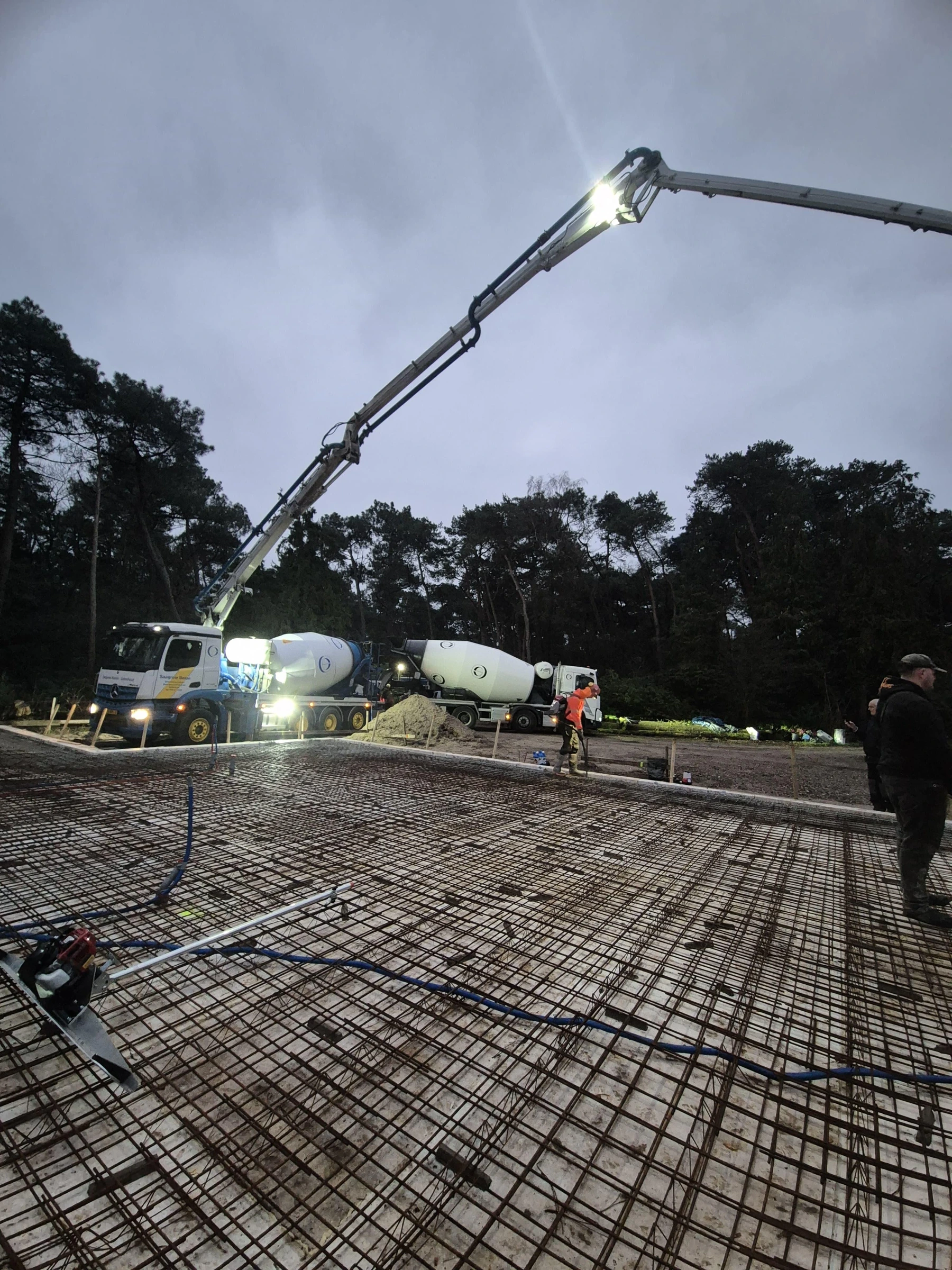 Beton storten met betonpomp en mixers op de bouw